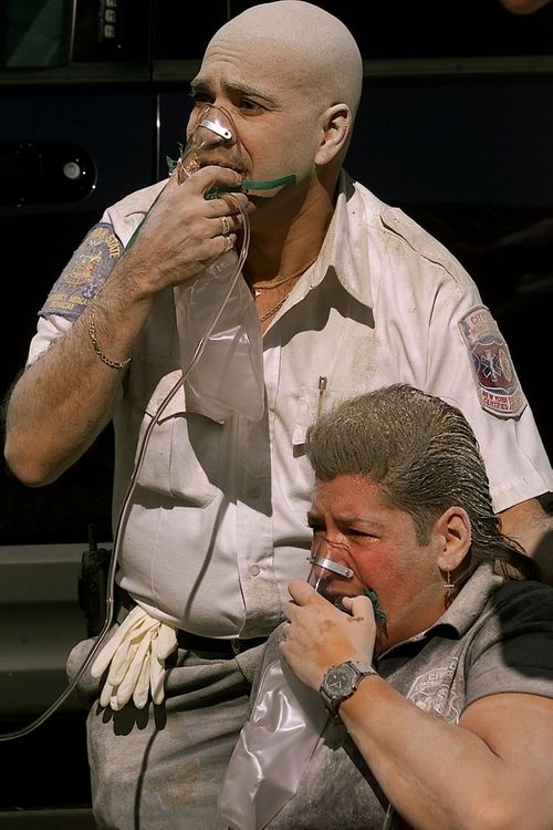 A paramedic and a policemen breath oxygen after the South Tower crumbled down. 