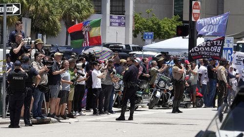People watch as they motorcade carrying former President Donald Trump arrives at the Wilkie D. Ferguson Jr. US Courthouse, Tuesday, June 13, 2023, in Miami