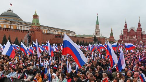 People gather during celebrations marking the incorporation of regions of Ukraine to join Russia in Red Square with the Kremlin Wall and the Historical Museum in the background in Moscow, Russia, Friday, Sept. 30, 2022. 