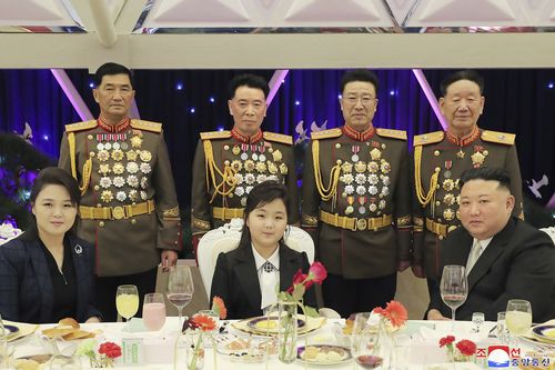 North Korean leader Kim Jong Un (right) with his wife Ri Sol Ju (left) and his daughter poses with military top officials for a photo at a feast to mark the 75th founding anniversary of the Korean Peoples Army at an unspecified place in North Korea on Tuesday.