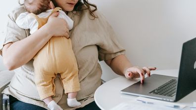Stock image of a mum with a baby and a laptop.