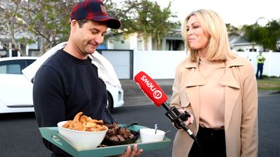 New Zealand Labour Party leader Jacinda Ardern's partner Clarke Gayford delivers home cooked food to the media waiting outside their house on October 17, 2020 in Auckland, New Zealand