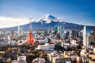 Aerial view of Mt. Fuji, Tokyo Tower and modern skyscrapers in Tokyo on a sunny day.