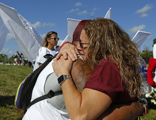 India Godman, left, hugs Wendy Garrity at Marjory Stoneman Douglas High School in Parkland. (AAP)