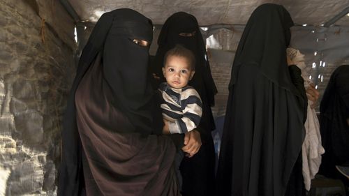 Zahra Ahmed (left) holding her son Ibrahim in the al-Hawl camp.