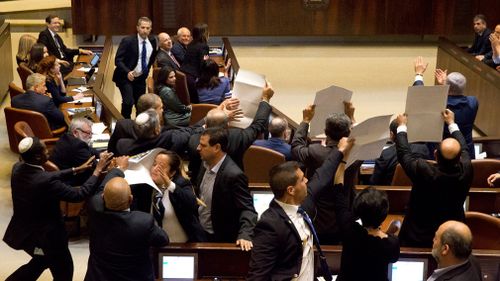 Israeli Arab members hold signs in protest as security pushes them out amid US Vice President Mike Pence's speech in Israel's parliament in Jerusalem. (AAP)