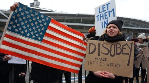 Protesters gather outside New York's JFK airport. (AAP)