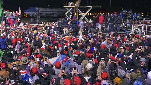 Trump supporters try to glimpse and document Air Force One as it taxies past them.