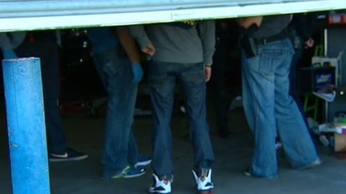Police inside the garage of a mechanic's workshop in Epping, Melbourne. (9NEWS)