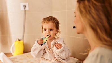 A toddler brushing her teeth