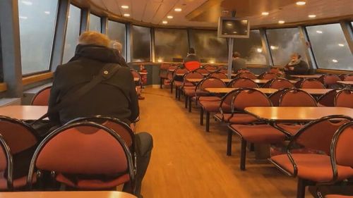 The wave crashed through the large window the ferry sending glass flying and passengers fleeing. 