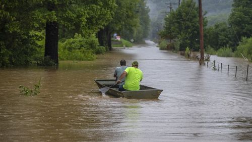 Men ride in a bpsy along flooded Wolverine Road in Breathitt County, Ky., on Thursday, July 28, 2022. Heavy rains have caused flash flooding and mudslides as storms pound parts of central Appalachia. Kentucky Gov. Andy Beshear says it's some of the worst flooding in state history. (Ryan C. Hermens/Lexington Herald-Leader via AP)