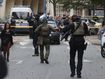 Elite police officers of the RAID squad patrol after a man armed with a knife killed a teacher and wounded two others at a high school in northern France, Friday, Oct. 13, 2023 in Arras.  