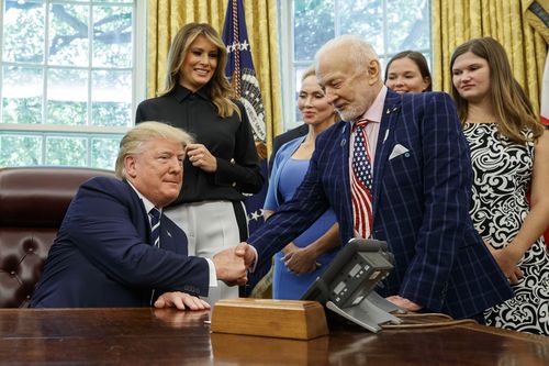 President Donald Trump shakes hands with Apollo 11 astronaut Buzz Aldrin, with first lady Melania Trump.