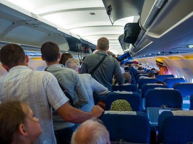 passengers standing on a plane