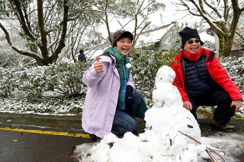Tourists enjoy the snow at Yangming Mountain in Taipei