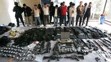 Men arrested by Mexican federal police stand behind weapons found in a home in Mexico City in 2008. Eleven alleged hit men working for the Sinaloa drug cartel were captured at two Mexico City mansions stocked with grenades, automatic weapons and body armour.
