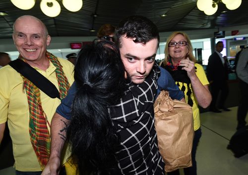 Anti-Islamic State fighter Ashley Dyball is greeted by family and supporters as he arrives at Brisbane airport in December, 2015. The former professional power lifter was in Syria fighting with the Kurdish YPG militia group Lions of Rojava against Islamic State. (AAP)