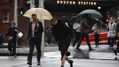 People are seen braving the rain on Friday, 23 May, 2025. The coastal trough responsible for bringing record rain to northern NSW has become more mobile after it was parked for days over soaked catchments. Picture - Sam Mooy / The Sydney Morning Herald