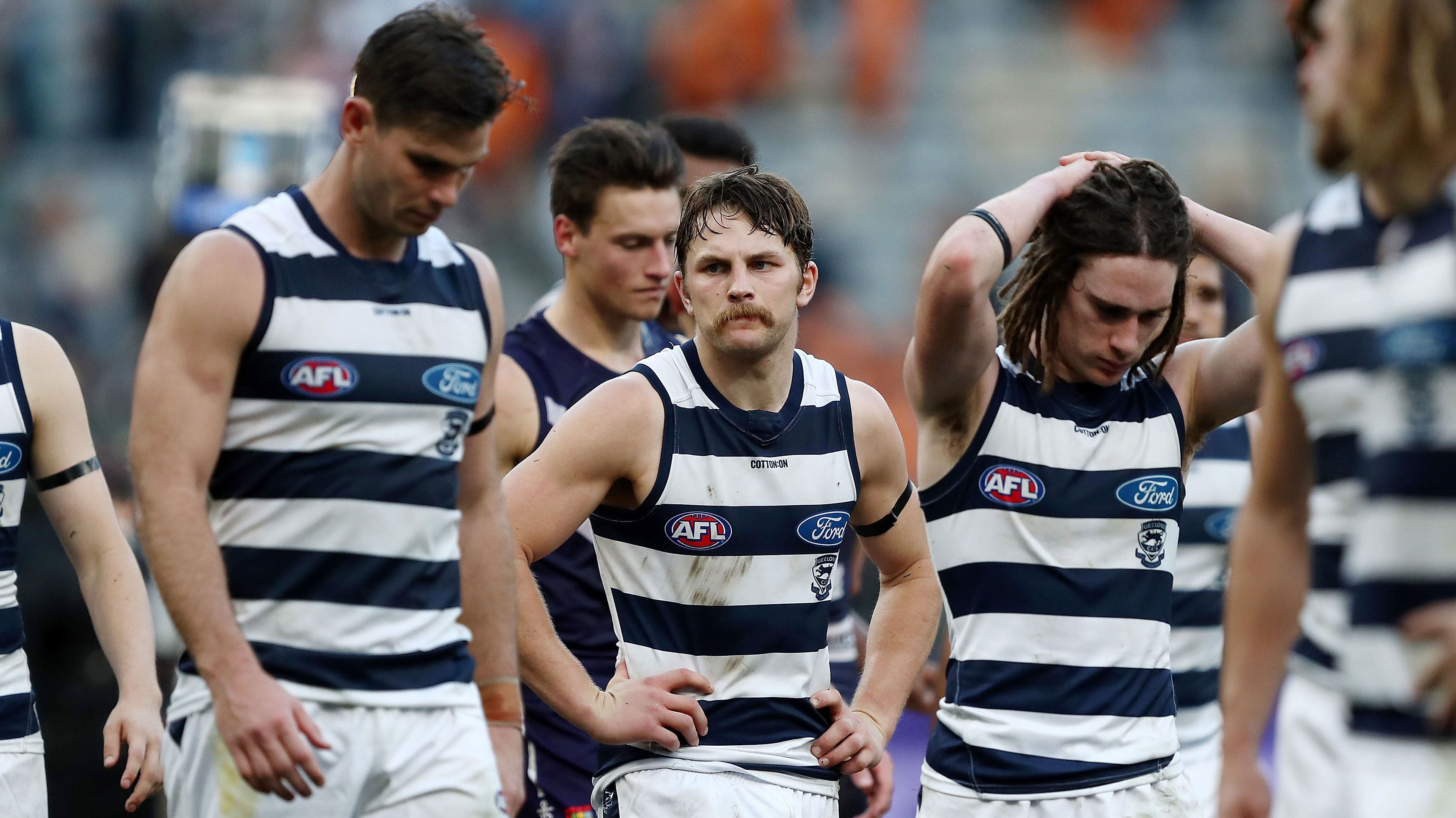 Geelong Cats players react to their loss to Fremantle.