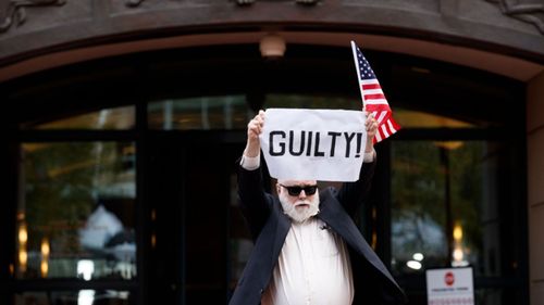 An activist reacts to the announcement that former Trump campaign chairman Paul Manafort has been found guilty to count one in US District Court in Alexandria, Virginia.