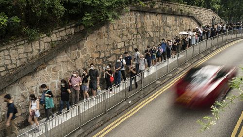 People wait in line to pay tribute to Queen Elizabeth II outside the British Consulate in Hong Kong, Friday, Sept. 16, 2022. 