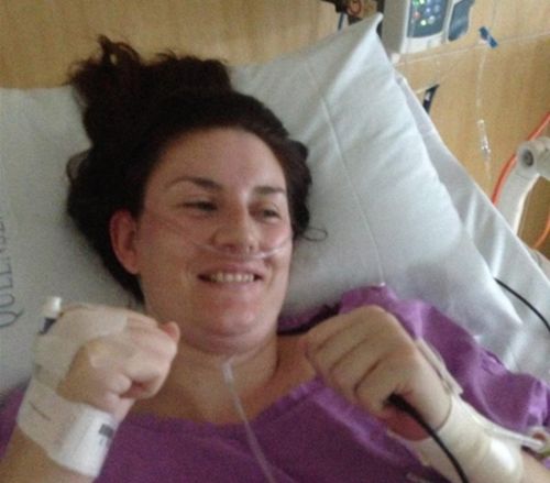 Queensland mum Casey poses with 'fighting fists' in hospital. (Supplied)