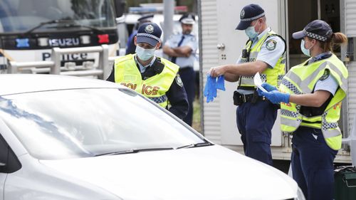 Canberra residents who have been stranded at the Victorian/NSW border arrive at a police checkpoint at Hall, at the NSW/ACT border, on Thursday 13 August 2020. 