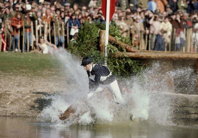 HRH Princess Anne, The Princess Royal, riding Stevie B, falls at the water jump during the cross country equestrian event at the Badminton Horse Trials on 1st May 1982  in Badminton Park, Gloucestershire, England. It was this fall that led to the often quoted 'naff off' comment made by Her Royal Highness to photographers. 