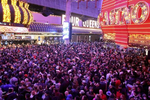 2021년 12월 31일 금요일, 라스베이거스 시내의 프리몬트 스트리트 익스피리언스(Fremont Street Experience)에서 축제를 즐기는 사람들이 새해 전날을 축하합니다. 