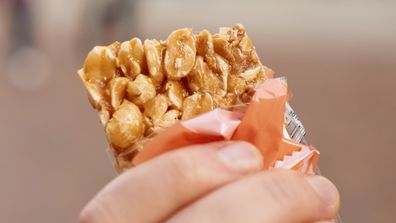 Honey bars with peanuts in the hand. Sweet candy snack