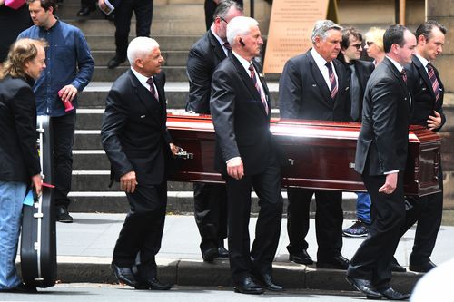 Angus watches the pallbearers place the casket in the hearse. Picture: AAP