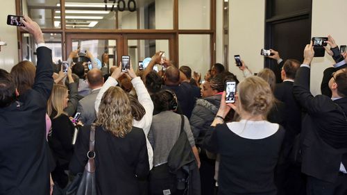 People rush the doors of the jury assembly room as former President Barack Obama arrives for jury duty (Kevin Tanaka/Sun Times via AP)