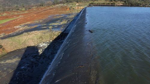Officials said the dam will continue flow over the emergency spillway for at least another 38 hours. (AAP)