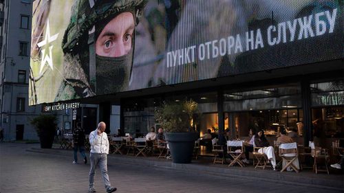 A Russian military recruitment sign above a Moscow cafe.