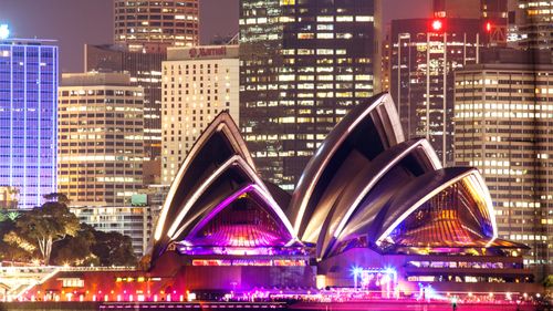 The Sydney Opera House and Sydney's skyline at night.
