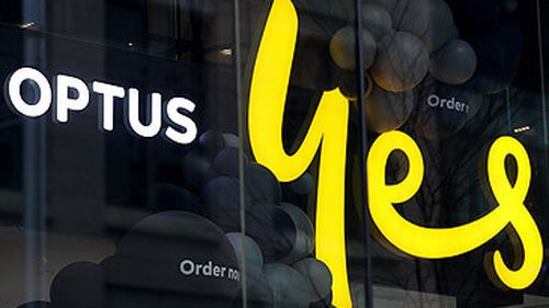 Optus logo and Yes sign in shop window (Getty)