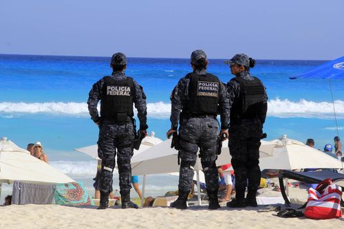 Troops patrol Cancun's beaches, but authorities appear powerless to stop the escalating bloodshed. (AAP)