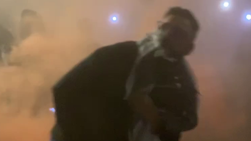 Un homme semble lancer une fusée éclairante lors d'une manifestation
