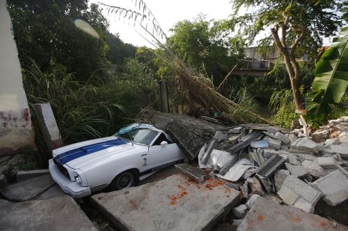 A car sits partially buried by debris from the earthquake. (AP)