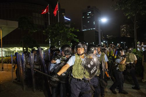Riot police officers seen trying to removing protesters near the legislative council building.