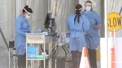 Health workers at a testing clinic in Indooroopilly State High school in Brisbane.