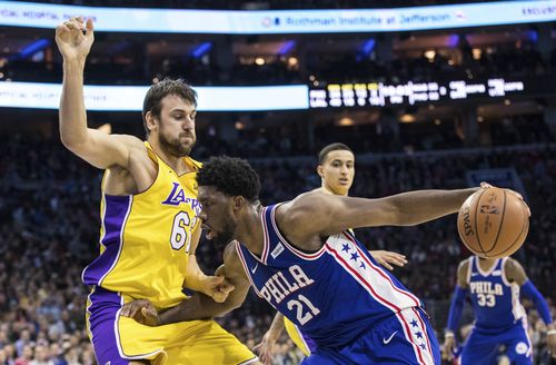 Philadelphia 76ers Joel Embiid, (front right) of Cameroon, makes his move against Los Angeles Lakers Andrew Bogut, left, of Australia, during the second half of an NBA basketball game in December last year. (AAP)