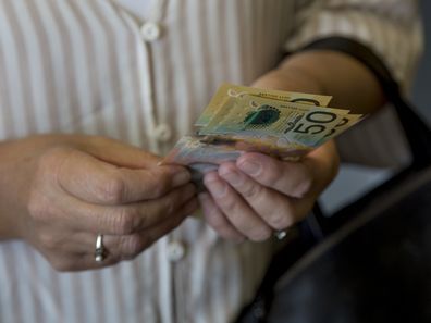 Woman holding Australian cash.