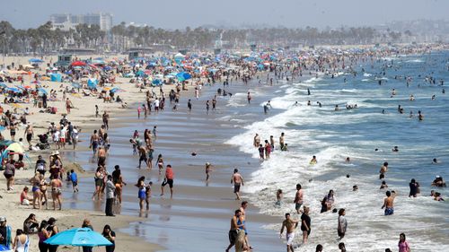 Visitors crowd the beach in Santa Monica, California in July, during the coronavirus pandemic.