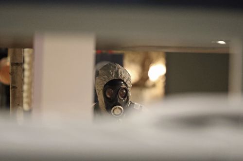 Investigators in hazmat suits inside the Zizzi restaurant. (AAP)