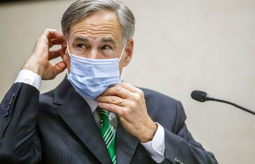  Texas Gov. Greg Abbott adjusts his mask.
