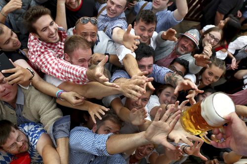 People reach out for a glass of beer during the opening of the 'Oktoberfest' beer festival in Munich.