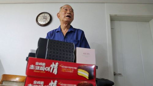 Kim Kwang-ho, 79, speaks in front of some gifts for his family members in North Korea during an interview at his home in Seoul, South Korea. (AAP)