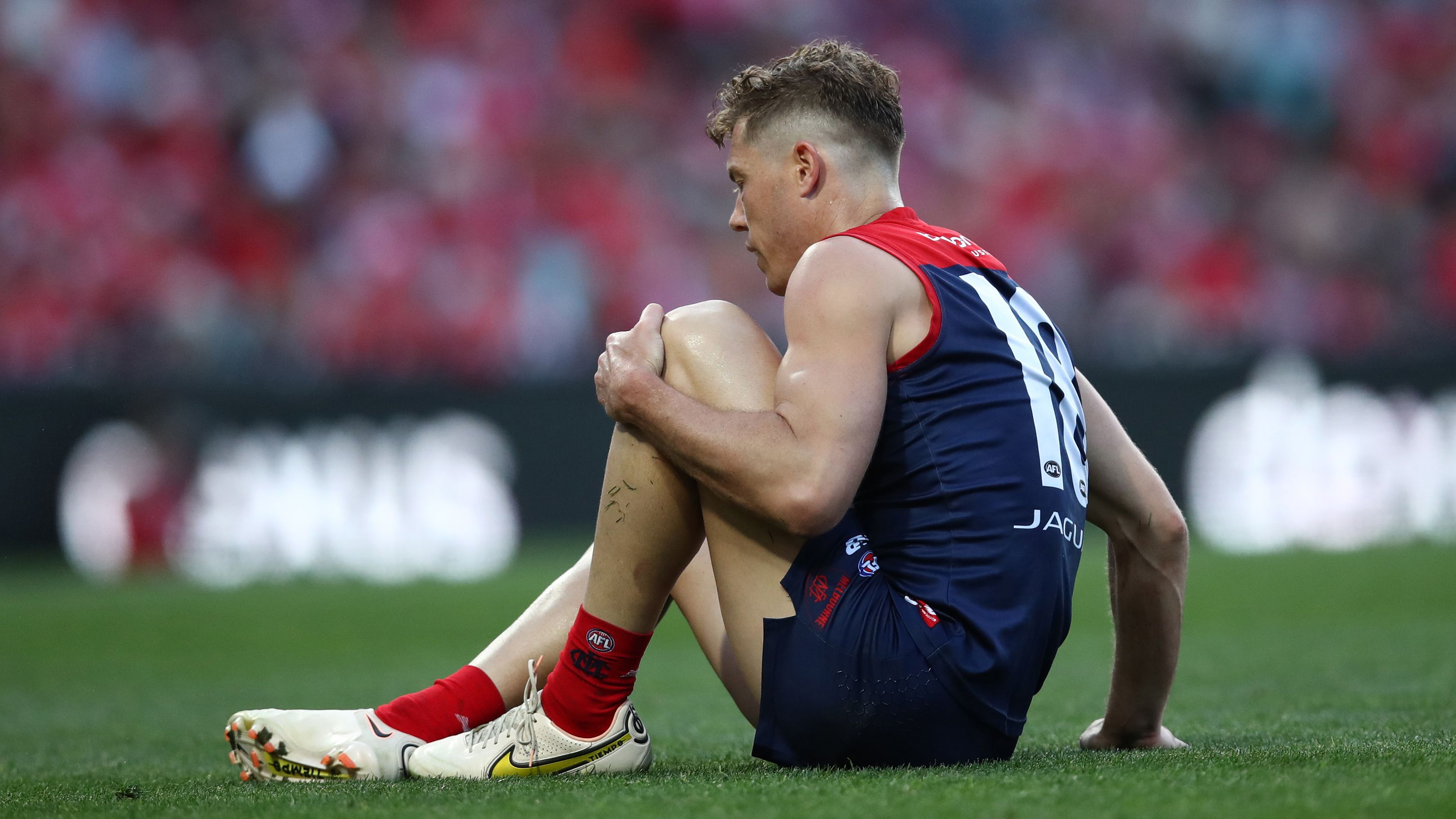 SYDNEY, AUSTRALIA - AUGUST 27: Jake Melksham of the Demons holds his knee during the round 24 AFL match between Sydney Swans and Melbourne Demons at Sydney Cricket Ground on August 27, 2023 in Sydney, Australia. (Photo by Jason McCawley/AFL Photos/via Getty Images )